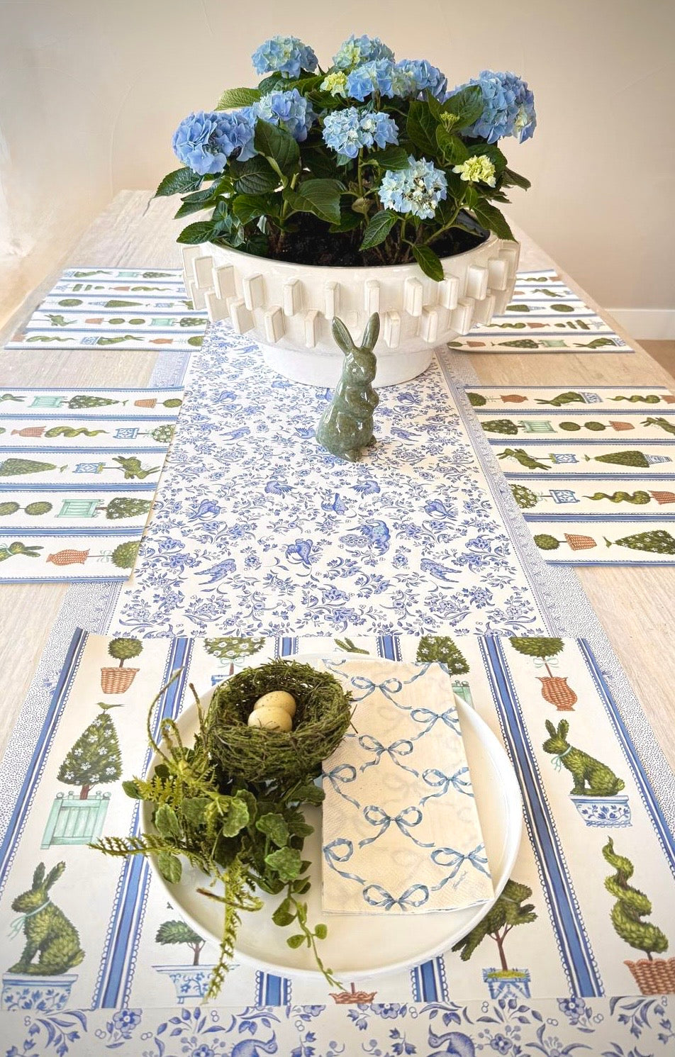 Decorative table setting with a floral centerpiece and bunny placemats.